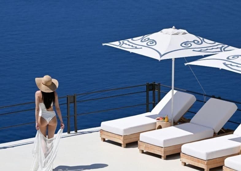 Guest gazing out on the endless blue horizon, enjoying the benefits of Andronis’ bespoke luxury experiences in Greece.  