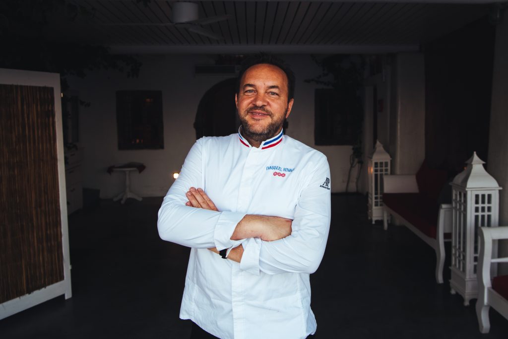 Portrait of Chef Emmanuel Renaut, standing with his hands crossed in front of his chest.