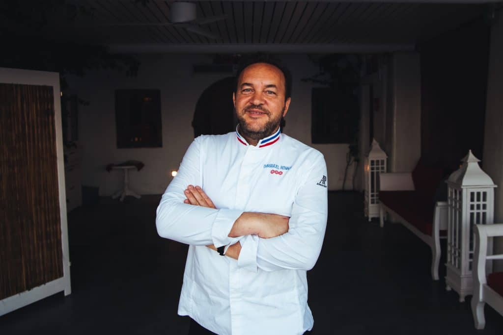 Portrait of Chef Emmanuel Renaut, standing with his hands crossed in front of his chest.