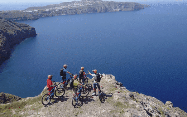 4 pessoas em bicicletas eléctricas de montanha, admirando a vista de Santorini