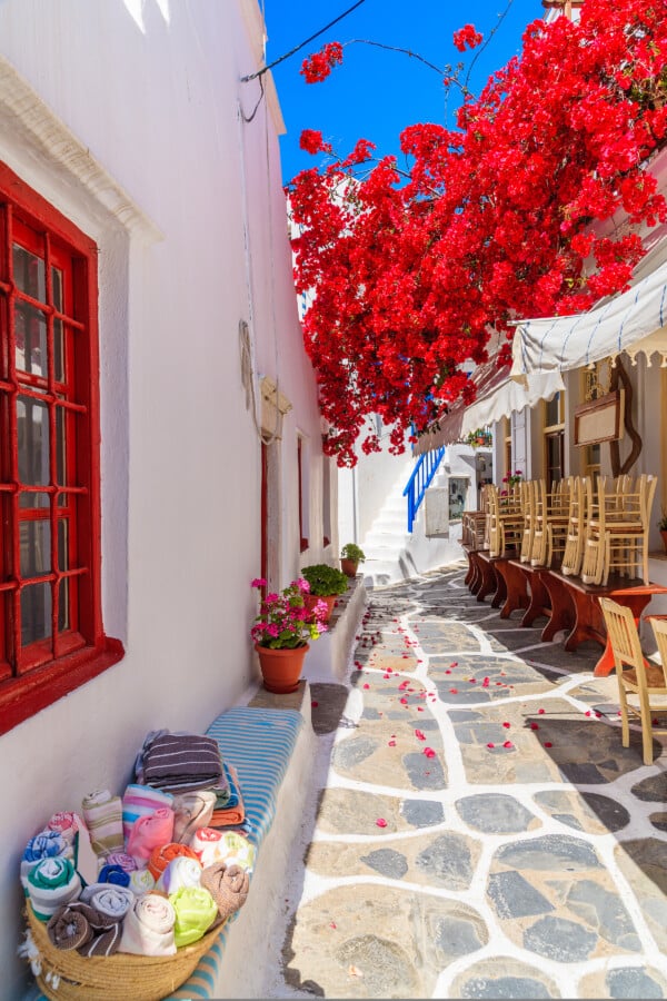 A,Narrow,Street,With,Flower,Decorated,Houses,In,Mykonos,Town,